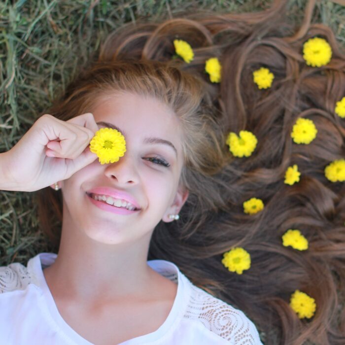 girl with yellow flowers in her hair laying on ground