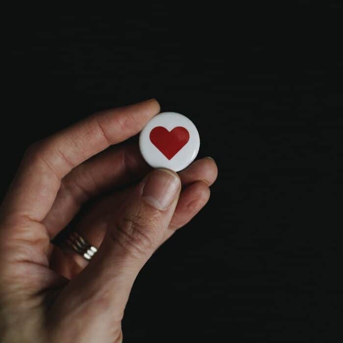 hand holding a heart button