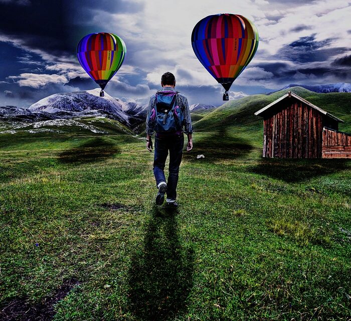 man walking toward cabin and hot air balloons