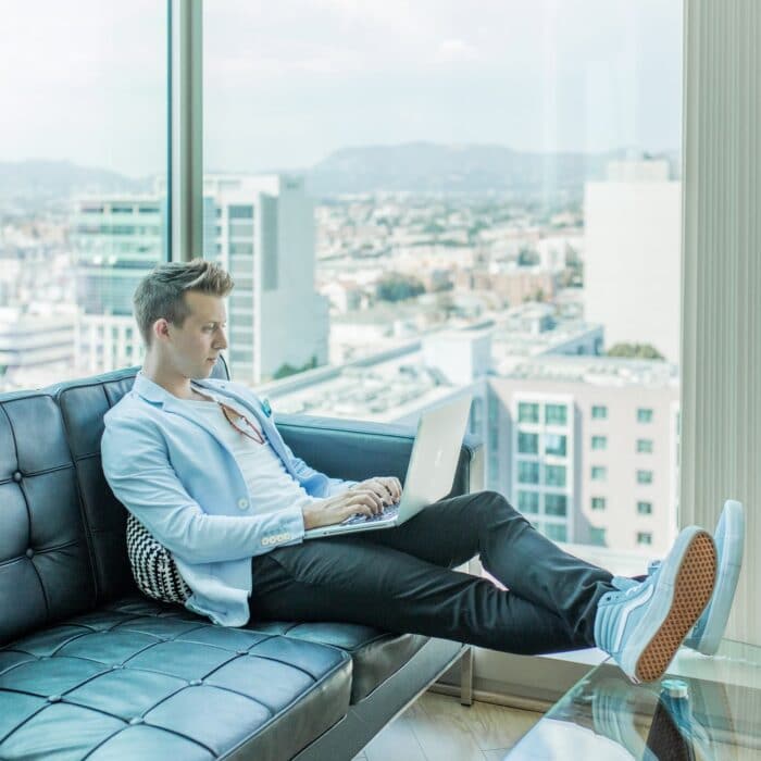 man on laptop with windows in skyscraper