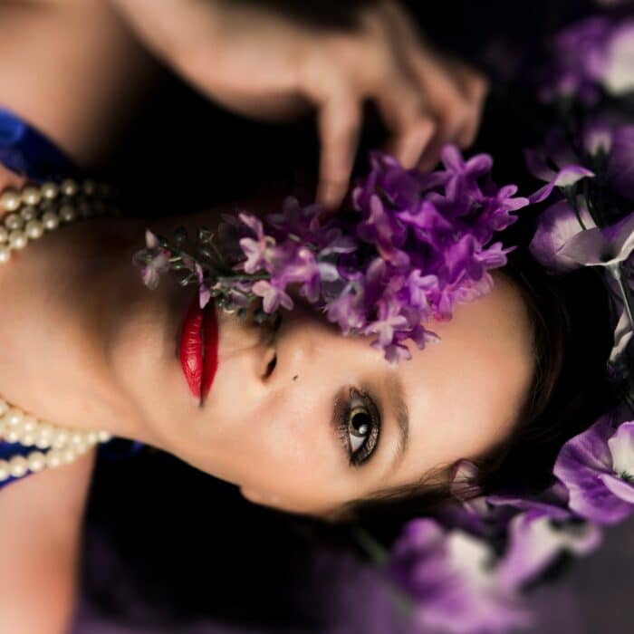 woman laying on a bed with a purple flower