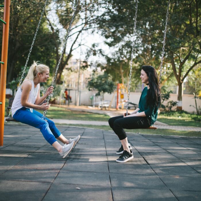 women on swings talking to each other chat influencer