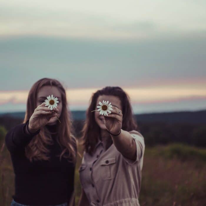 two women holding flowers friends influencer