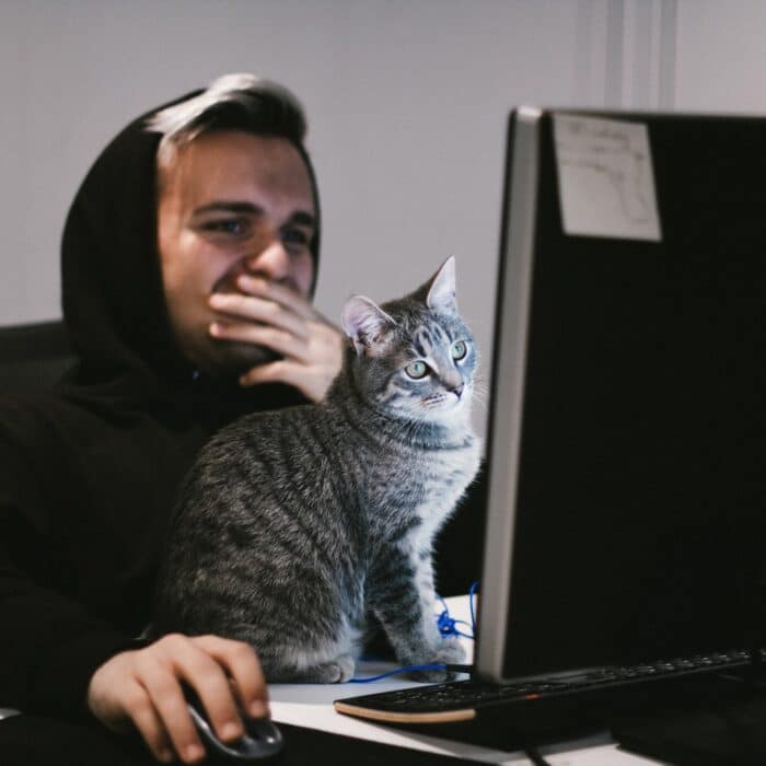 man and cat on desktop thinking