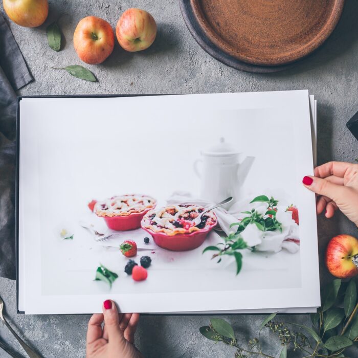 woman holding pictures of pie with apples portfolio