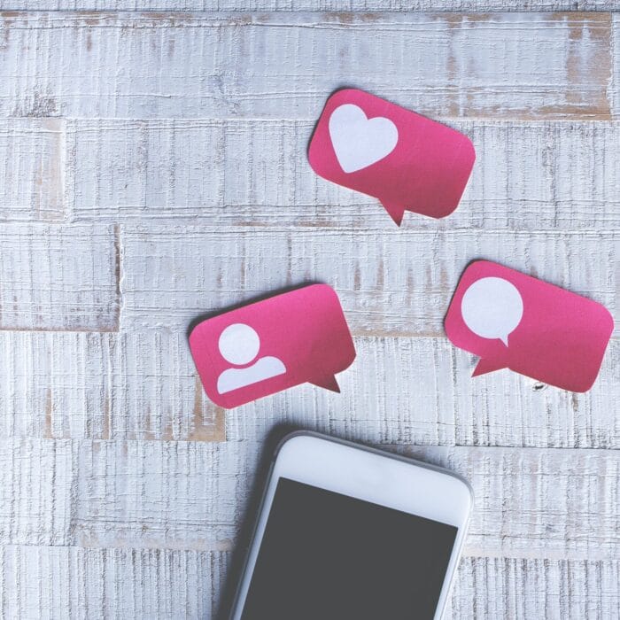 chat stickers above a mobile phone social media likes and follows