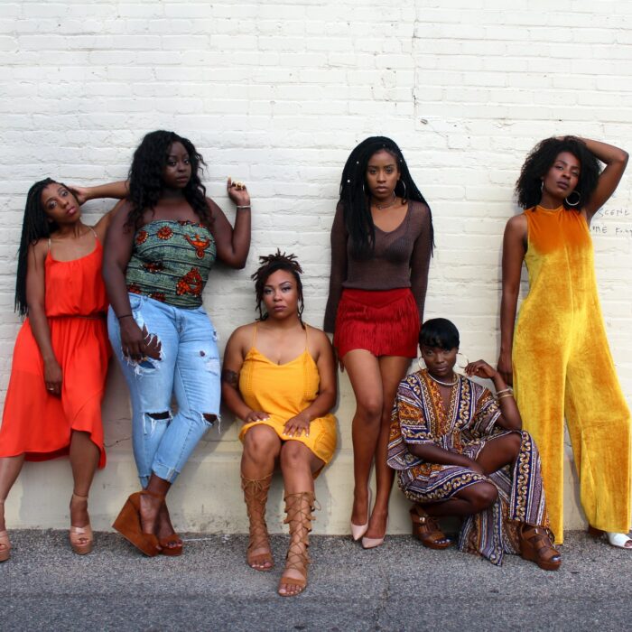 women leaning against wall group color clothes