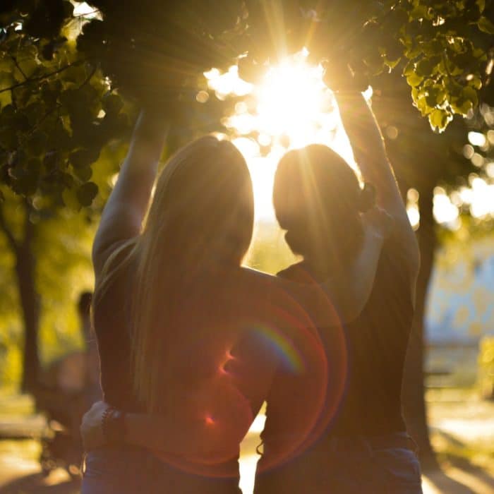 two women hugging with sun beam