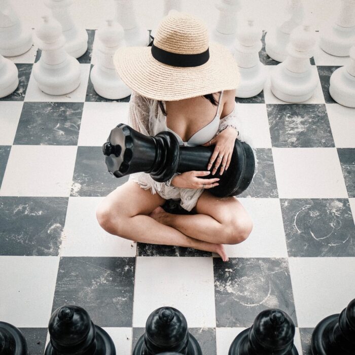 woman holding a chess piece on a chessboard