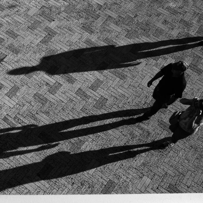 couple walking down the street creating shadows light influencers