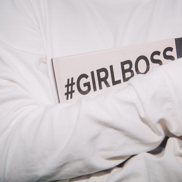hashtag girl boss on notebook in arms