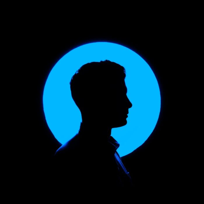 man standing in front of blue light identity
