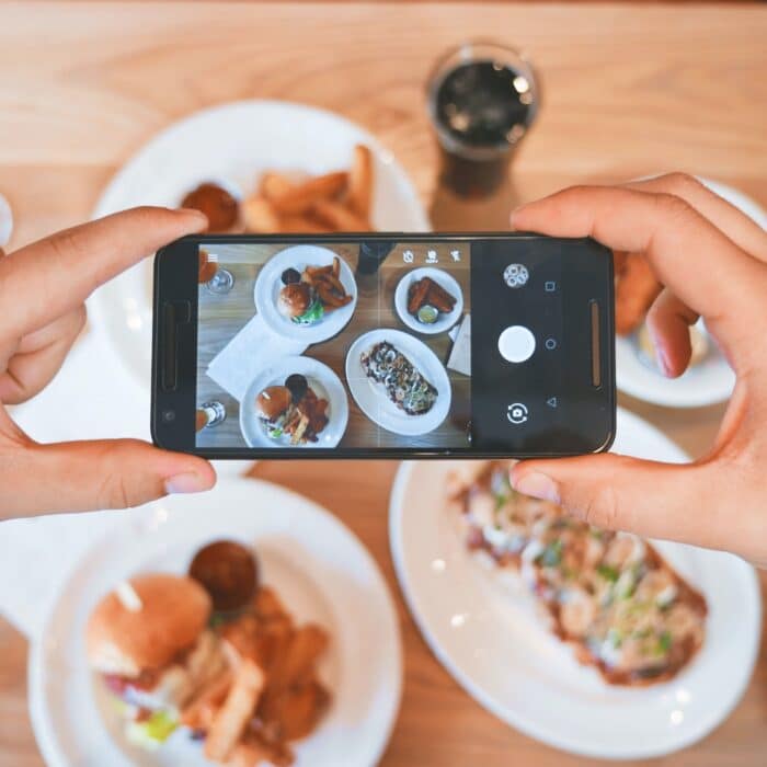 someone taking photo of food with mobile phone