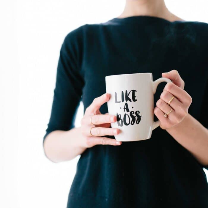 woman holding a like a boss coffee cup