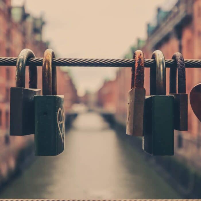 locks on a bridge over a river with buildings