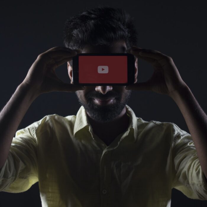 man holding youtube mobile phone up to face