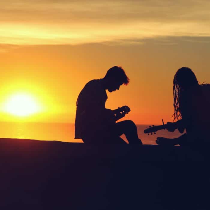 music on beach sunset couple man woman