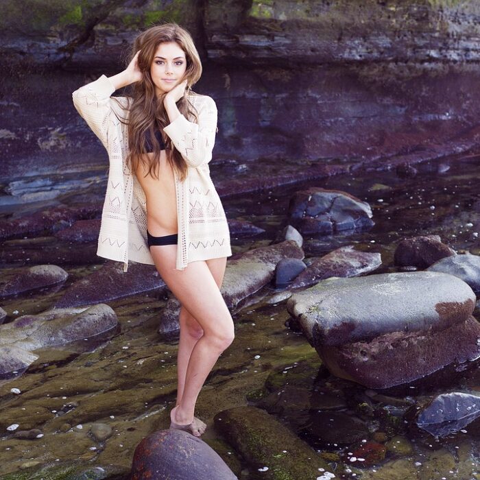 woman standing in a stream, bikini smiling, influencer