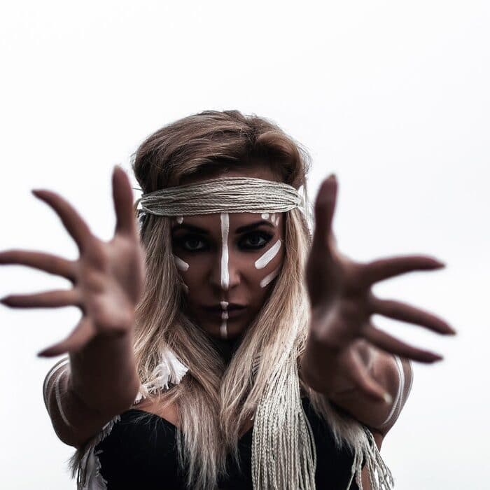 woman with paint on face, arms stretched out