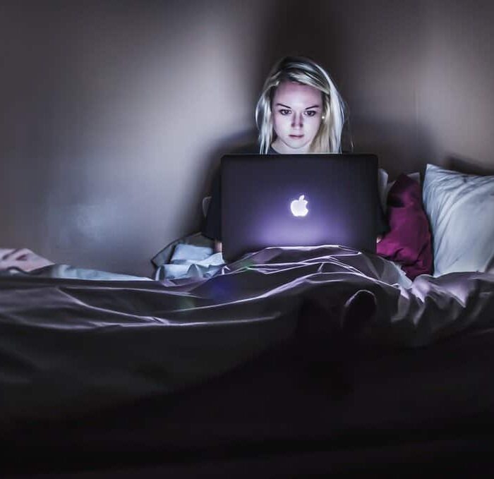 woman on bed with laptop