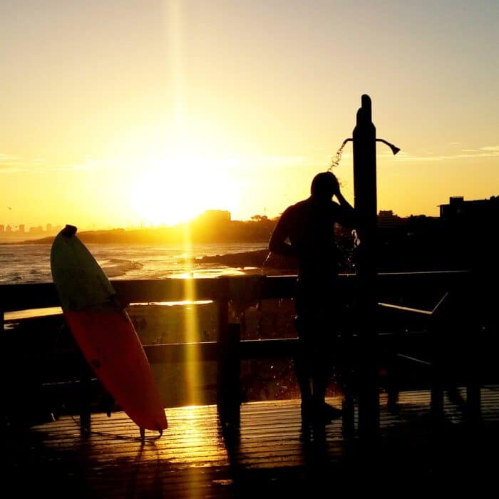 surfer showering in sunrise