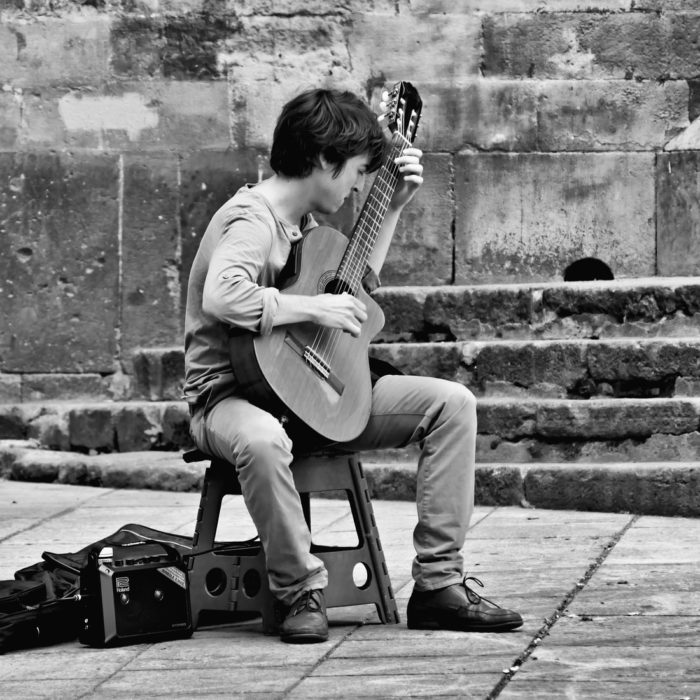 black and white man playing guitar