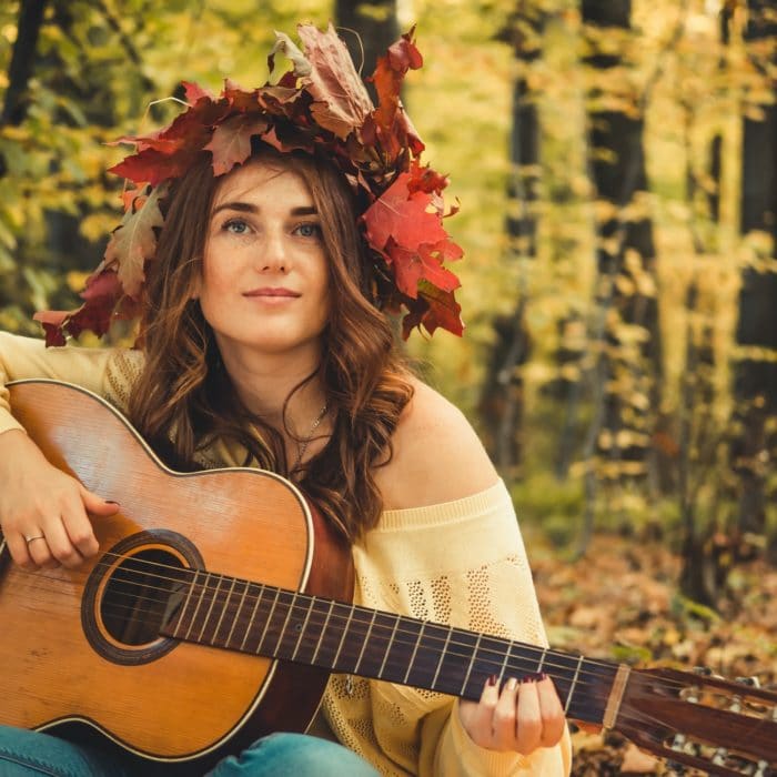 woman playing guitar leaves in hair