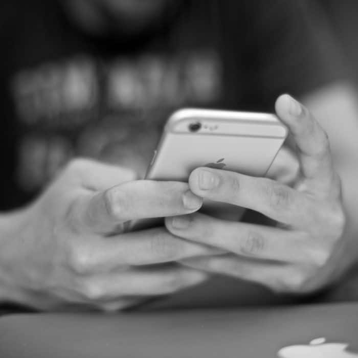 black and white photo of person holding phone