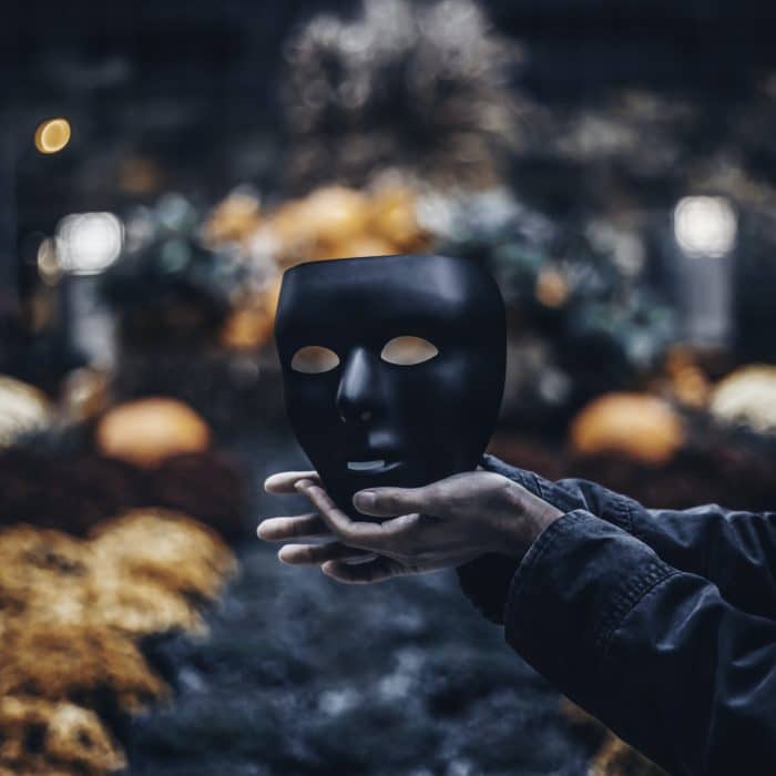 man holding out black mask