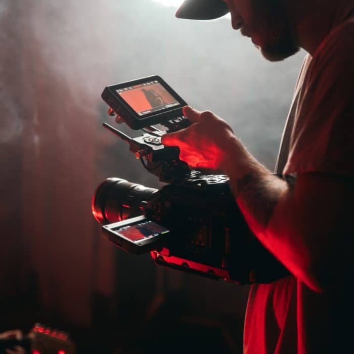 man holding video camera. red glow