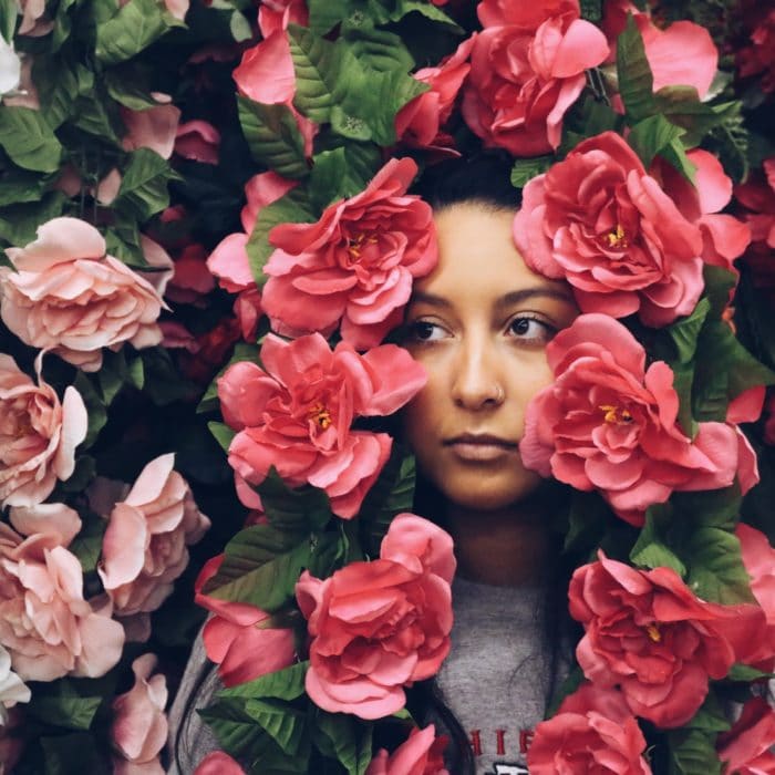 woman hiding in pink flowers