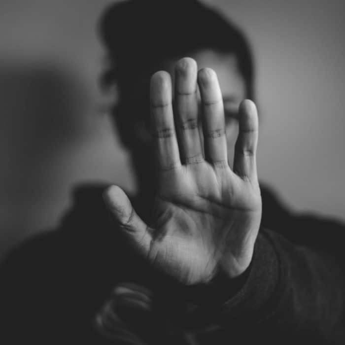 woman holding her hand in front of the camera black and white image