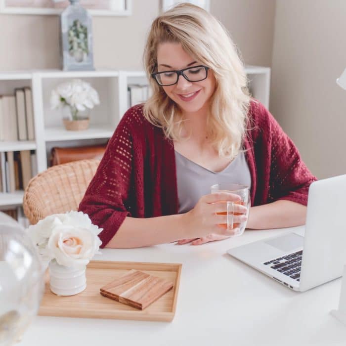 woman in front of laptop and flowers