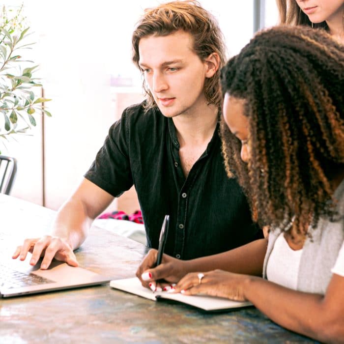 three people meeting in front of laptop