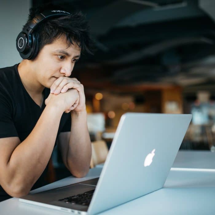 man in headset staring at laptop