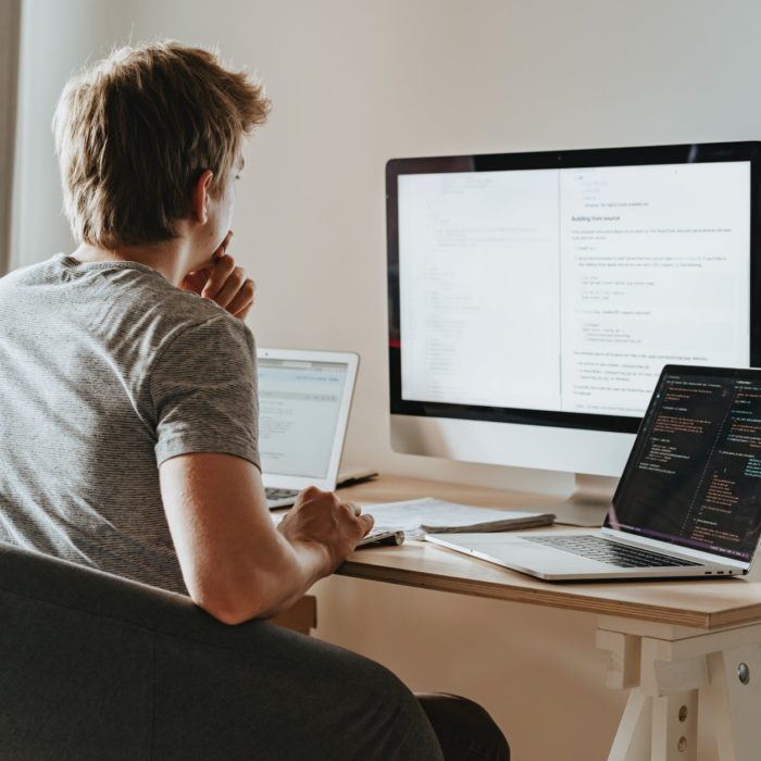 man thinking with desktop and laptop