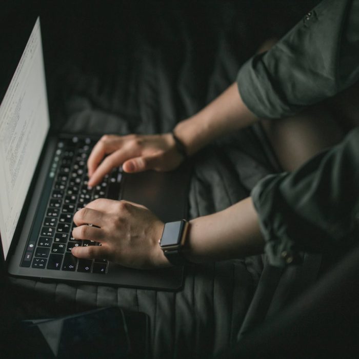 person in longsleeve short typing on laptop