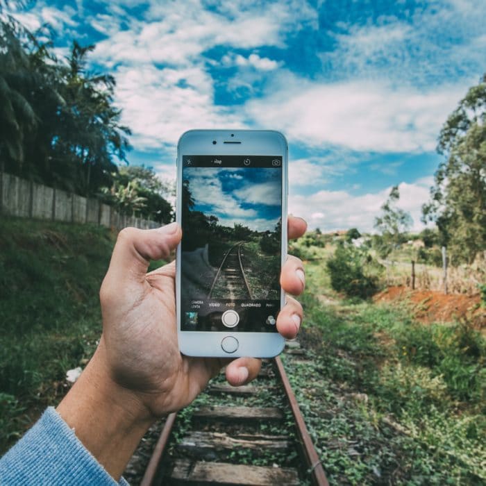 person taking photo of railroad track