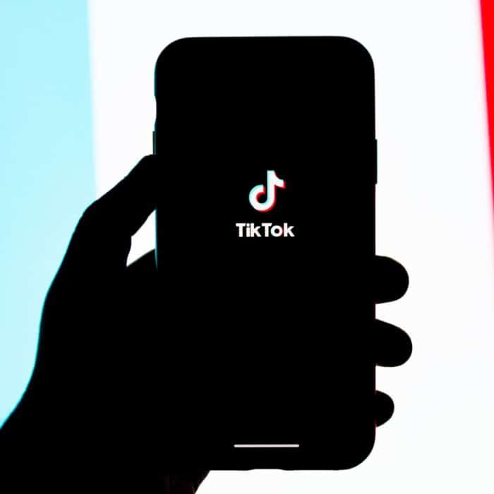 tik tok on phone with blue, white, and red background