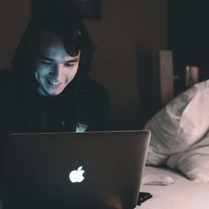 man on laptop in bed