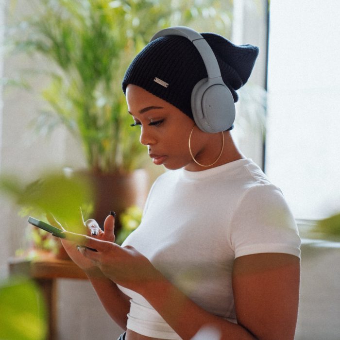 Woman Wearing Headphones Holding Phone
