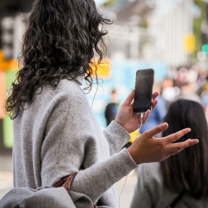 Curly Haired Woman Holding Phone