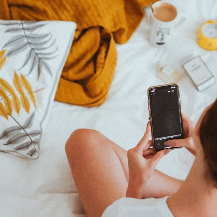 Woman Using Phone in Bed