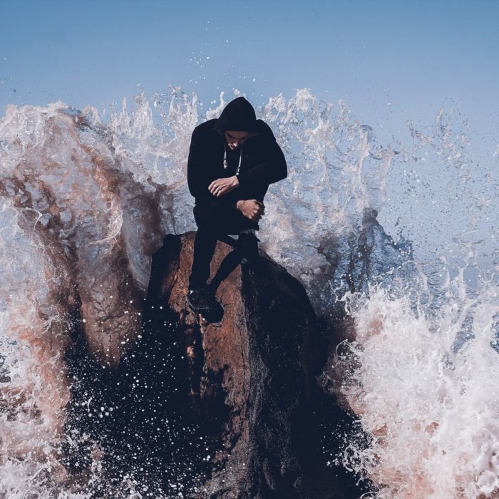 man on rock with waves
