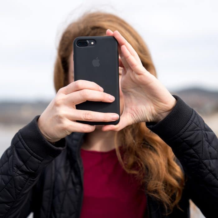 Woman Hiding Behind a Phone