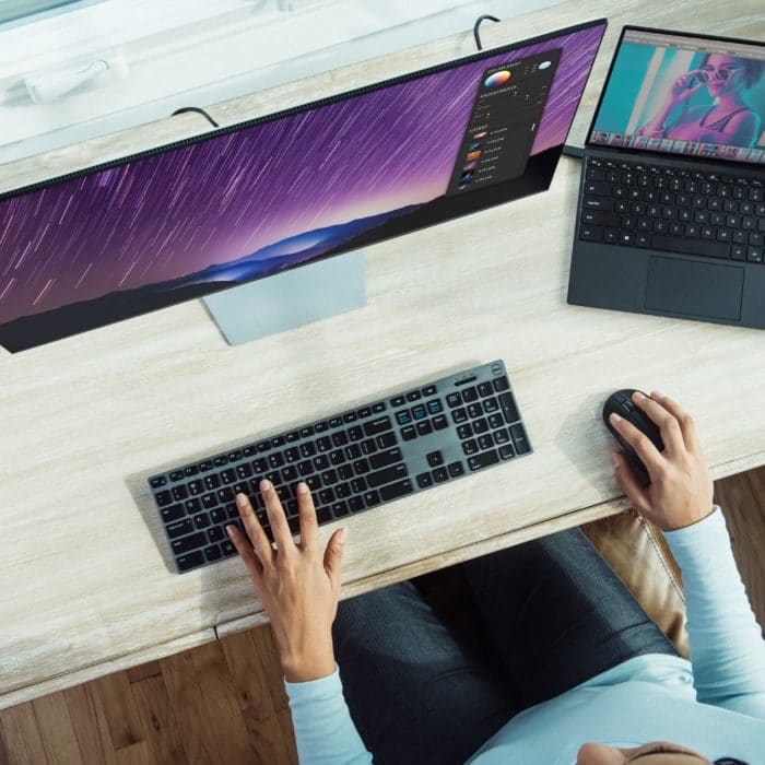 Woman Typing on Two PCs