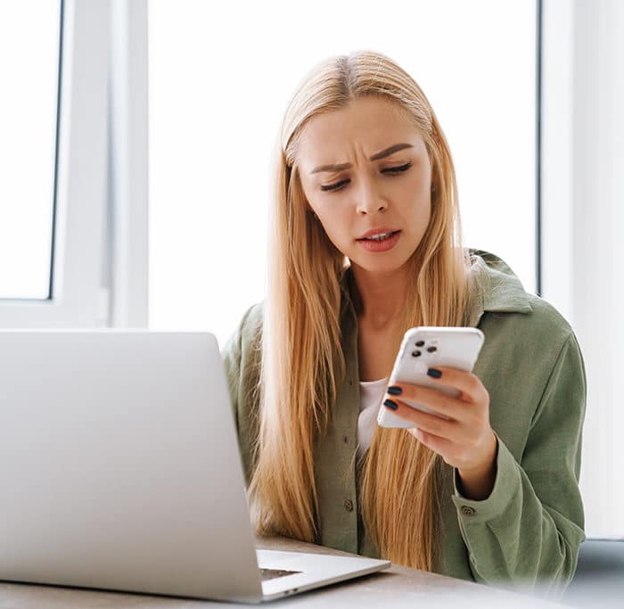 Woman Checking Her Phone and Laptop