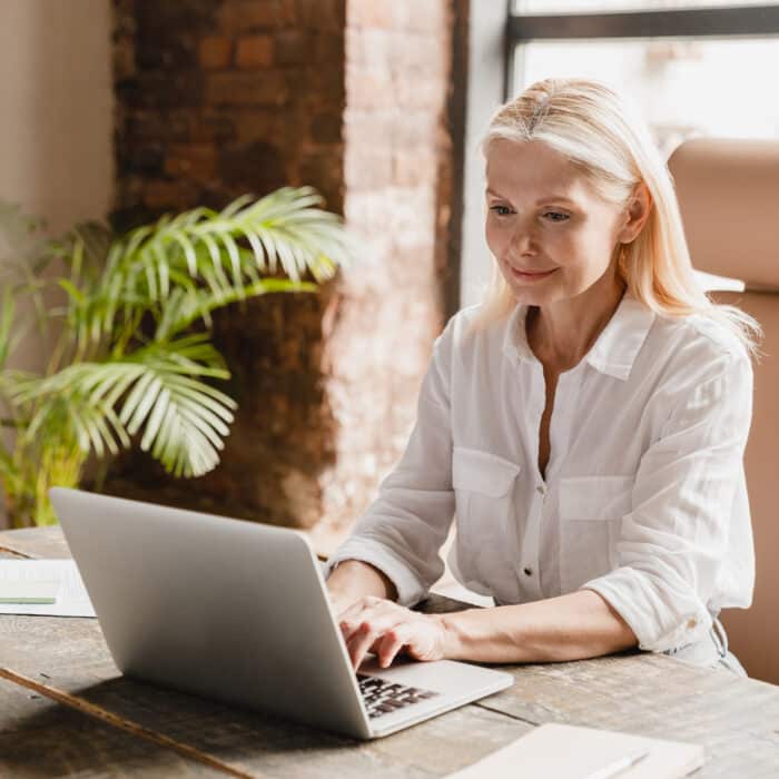 Remote workday concept. Caucasian mature businesswoman ceo freelancer tutor teacher working typing on laptop, searching information, social media surfing online in office