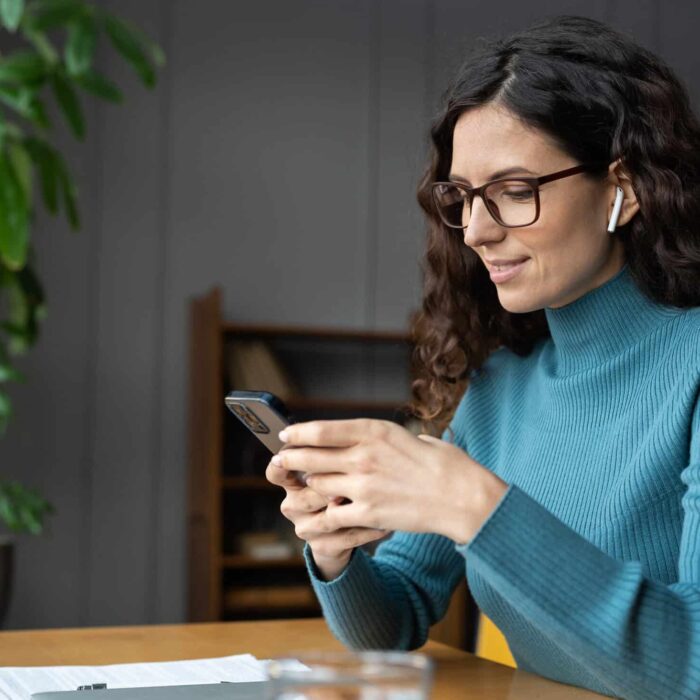 Young businesswoman check notification on smartphone online apps for social media management and ads